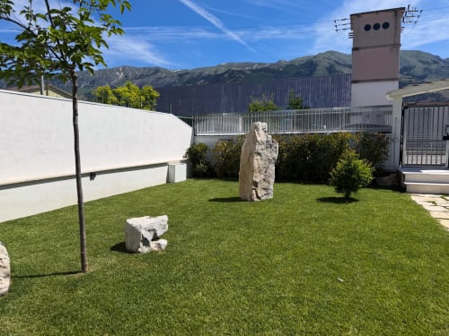 Innenhof des Hotels Stella CasaBono in Sulmona mit Kunstrasen, weißen Wänden und Bergblick