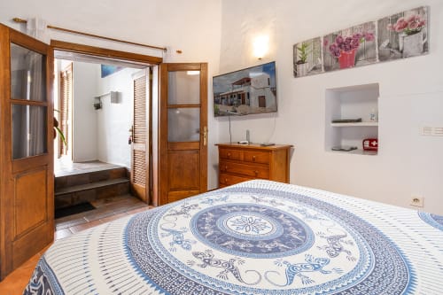 Habitación de lujo en Villanueva Lanzarote con ropa de cama azul estampada, muebles de madera y baño en suite en Mala