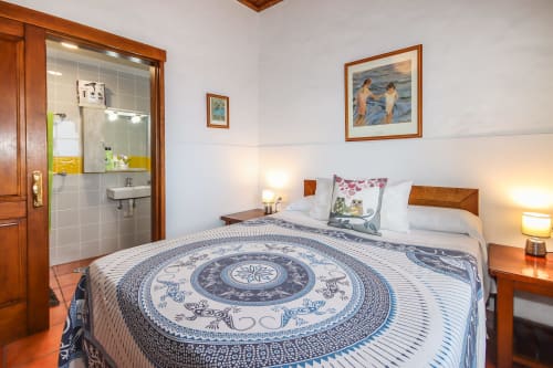 Dormitorio de apartamento deluxe en Villanueva Lanzarote con cama de madera, baño privado y vistas al océano