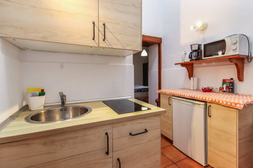 Cocina moderna en Apartamento Deluxe de Villanueva Lanzarote con muebles de madera, electrodomésticos inoxidables y toques naranjas