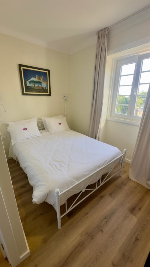 Quarto Queen amplo e luminoso na Pousada Pink-Shell em Santiago de Riba-UI, com roupa de cama branca, vistas para jardim e tons de amarelo claro