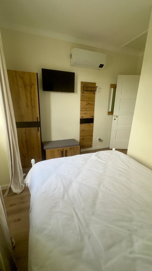 Quarto moderno na Pink-Shell B&B, Santiago de Riba-UI com cama queen, TV de plasma, guarda-roupa em madeira e ar-condicionado