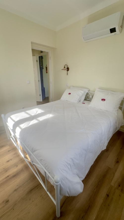 Luminoso Quarto Superior Queen no Pink-Shell B&B em Santiago de Riba-UI com roupa de cama branca, ar condicionado e piso em madeira