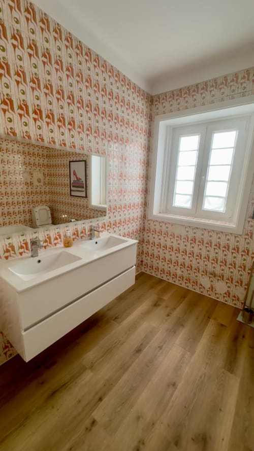 Banheiro moderno com lavabo duplo, papel de parede estampado, piso de madeira e janela na Pousada Pink-Shell Santiago de Riba-UI