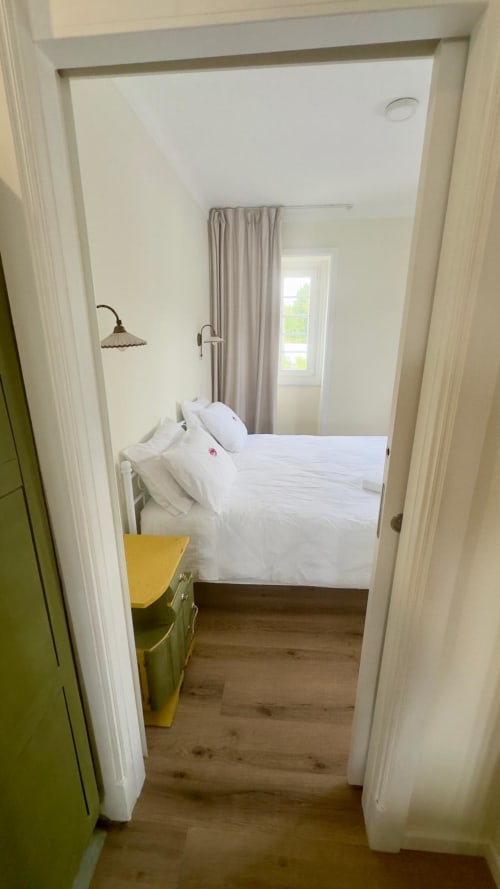 Quarto da Suíte Familiar no Pink-Shell B&B com roupa de cama branca, vista para o jardim e comodidades modernas em Santiago de Riba-UI