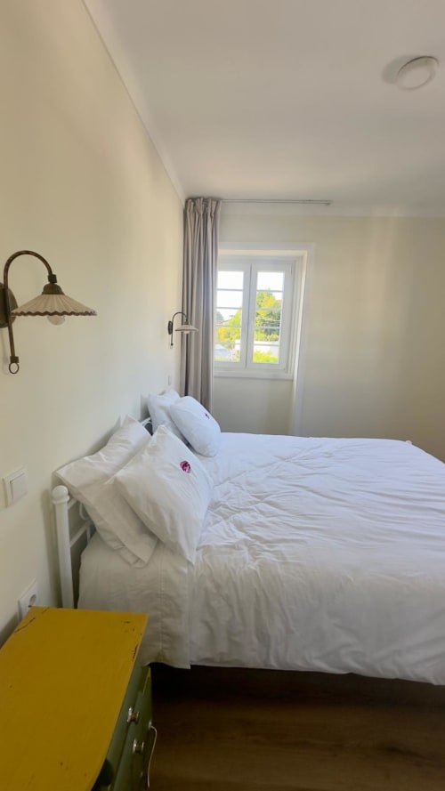 Quarto luminoso no Pink-Shell B&B em Santiago de Riba-UI com cama branca, portas com vista para o jardim, arandela vintage e