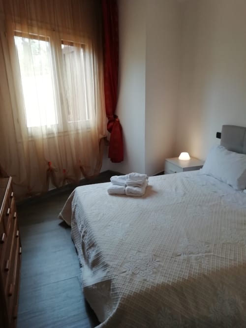 Camera luminosa di Villa Acquamarina con biancheria bianca, asciugamani freschi, vista sul giardino e luce naturale dalle finestre