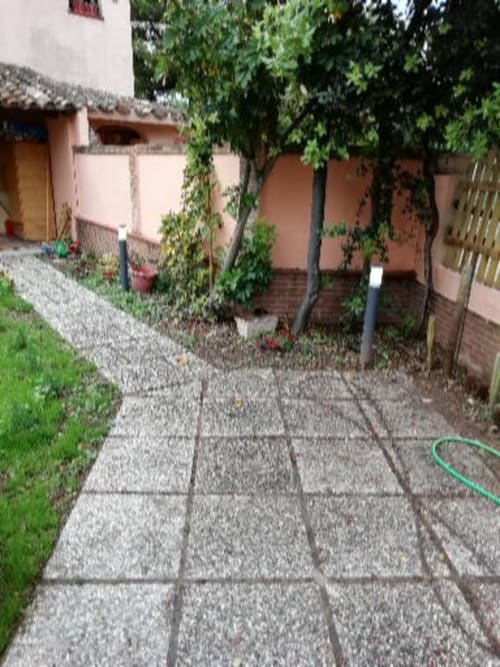 Viale del giardino con pavimentazione in piastrelle a Villa Acquamarina di Quartu Sant'Elena, circondata da rigogliosa vegetazione e alberi