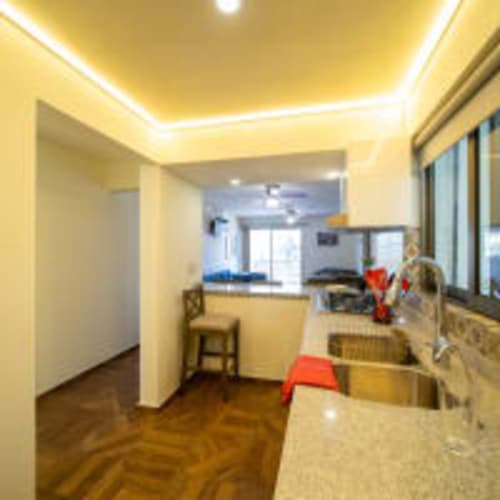 Cocina luminosa en Posada Country, Guadalajara con iluminación moderna amarilla y vistas de la ciudad
