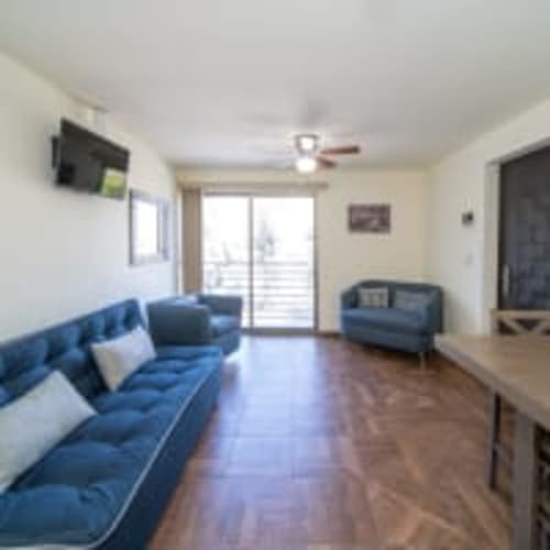 Luminosa sala de estar con sofá azul, televisor y vistas al balcón en Apartamentos Posada Country, Guadalajara