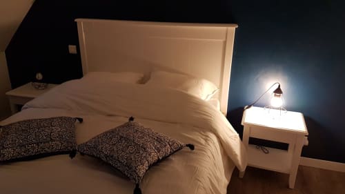 Lit king-size avec oreillers décorifs dans gîte Belle Île en Mer, lampe de chevet moderne et table de nuit