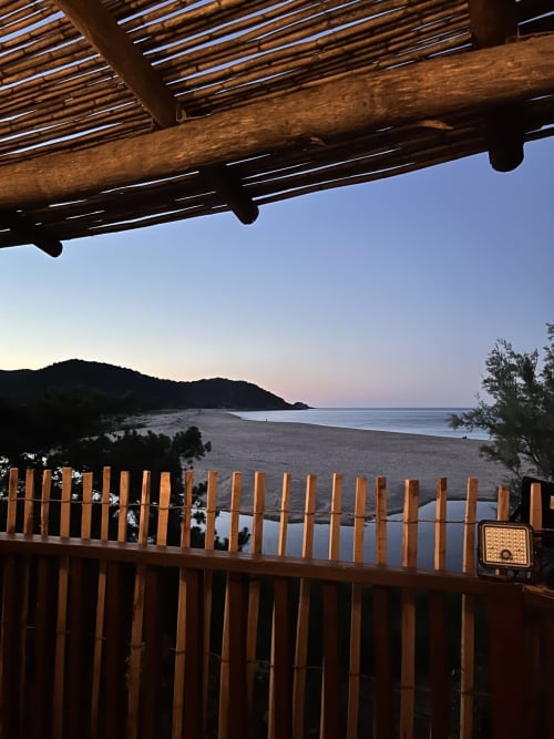 Vue du coucher de soleil depuis la terrasse de Villa Casa Blue Bas surplombant la côte de Zonza avec pergola et balustrade en bois