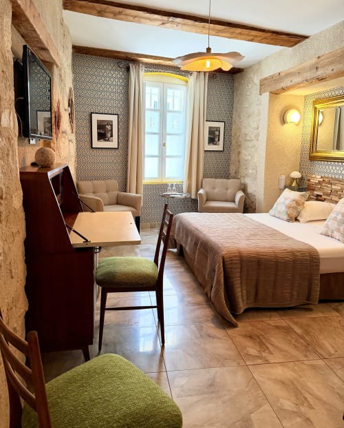 Luxuriöses Hotelzimmer im Hôtel La Suite in Villeneuve-lès-Avignon mit Bett, Sitzbereich, gemusterter Tapete, Elementen