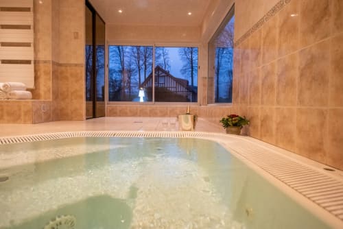 Sublime piscine intérieure du spa Clos Céleste à Ecrainville, vue vespérale sur l'architecture Tudor
