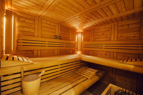 Intérieur de sauna en bois avec banquettes et éclairage ambiant au Clos Céleste, Ecrainville France
