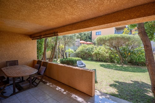 Terrasse ombragée avec table à manger à la villa Guddelmoni de Propriano, vue sur le jardin