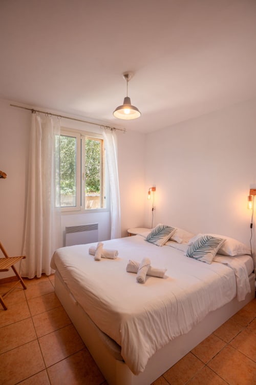 Chambre lumineuse à la villa Residence Guddelmoni à Propriano avec lits jumeaux, vue sur le jardin, suspension et teintes terracotta
