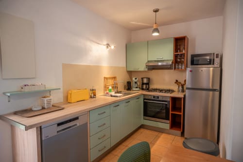 Cuisine moderne à la villa Residence Guddelmoni, Propriano, avec armoires vert menthe, électroménagers inox et bois