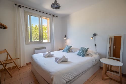 Chambre lumineuse à la villa Residence Guddelmoni à Propriano avec lit queen-size, vue sur le jardin et équipements modernes