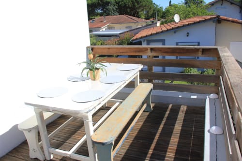 Terrasse en bois avec table à manger et banc au gîte Le Grand Bain, La Pause Landaise, Magescq