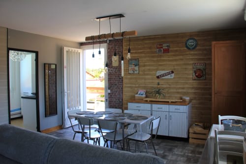 Séjour et salle à manger ouverts au cottage Le Grand Bain de La Pause Landaise, avec mur en bois, table à manger, cuisine