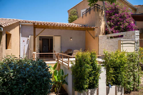 Mini villa avec terrasse privée à la Résidence Guddelmoni à Propriano, entourée de jardins luxuriants et de fleurs de bougainvillée