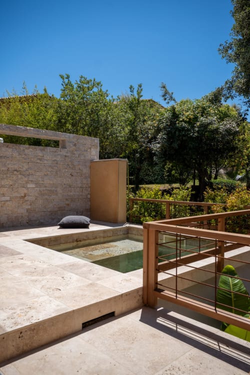 Terrasse privée avec piscine à la villa Guddelmoni à Propriano, patio en pierre, balustrades en bois et vue sur le jardin