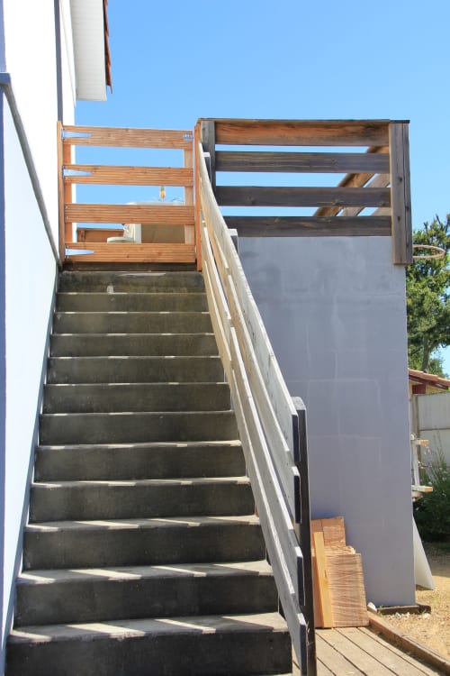 Escalier extérieur en béton avec rampe en bois menant au cottage Le Grand Bain à La Pause Landaise à Magescq, France