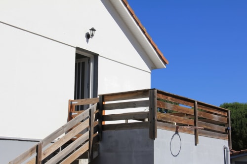 Terrasse et balustrade en bois menant au cottage Le Grand Bain de La Pause Landaise à Magescq avec vue sur la piscine