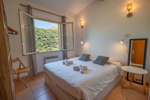 Chambre lumineuse à la villa Mini 5 de la Résidence Guddelmoni, Propriano, avec vue sur jardin, mobilier bois et équipements modernes