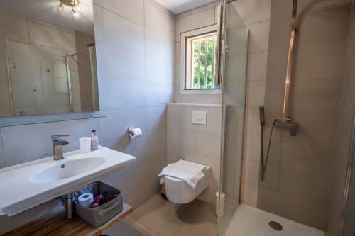 Salle de bain moderne avec lavabo, toilettes et douche à l'italienne à la villa Residence Guddelmoni à Propriano