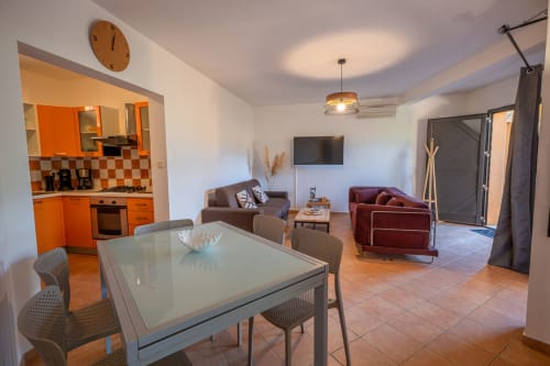 Appartement ouvert à la Résidence Guddelmoni à Propriano avec salle à manger, cuisine orange, salon et accès au jardin