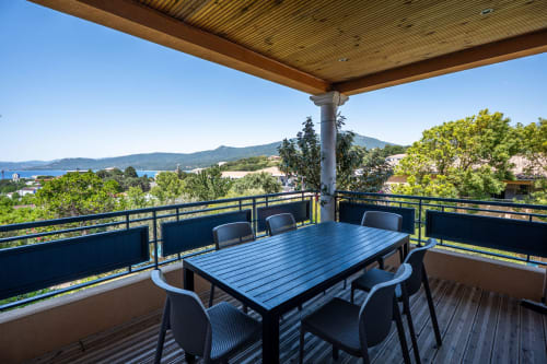 Terrasse privée avec table de salle à manger offrant une vue sur la baie de Propriano, les montagnes et la Méditerranée à la Résidence Guddelmoni