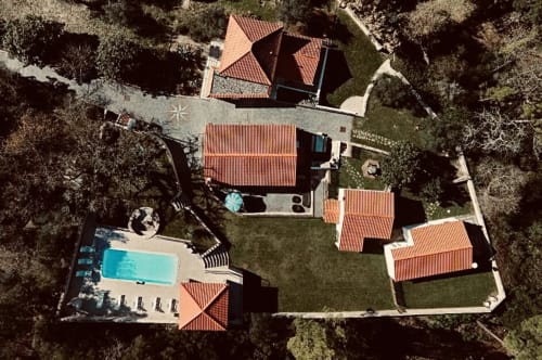 Aerial view of Quinta Boa Vida cottage in Alcobaça with terracotta roofs, pool, and lush garden surrounded by trees