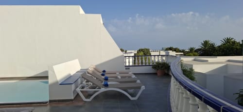 Terraza en la azotea de Villas del Mar en Puerto Calero con tumbonas, vistas a la piscina y horizonte oceánico