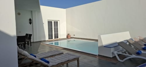 Terraza moderna de villa con piscina privada, tumbonas, sombrilla y vistas en Villas del Mar, Puerto Calero