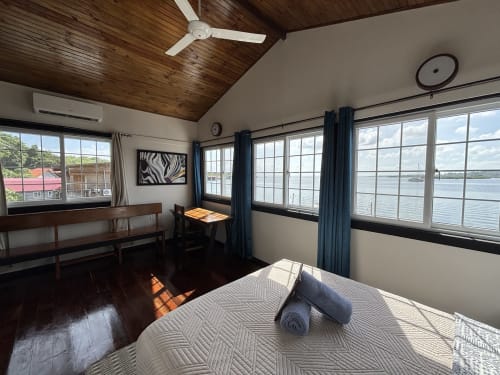 Amplia habitación premier en BarrBra BnB en Bocas del Toro con vistas panorámicas al océano, cama queen, zona de descanso, ventilador de techo y