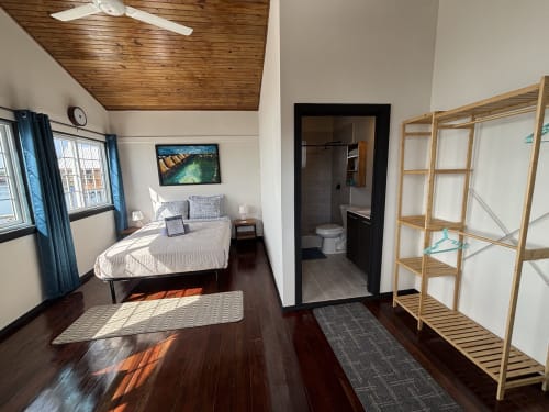 Habitación Queen Premier en BarrBra BnB en Bocas del Toro con techo de madera, cama queen y arte con vistas al océano