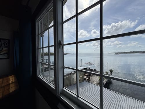 Vista panorámica del océano desde la habitación Premier Queen del BarrBra BnB en Bocas del Toro, con terraza frente al mar y veleros
