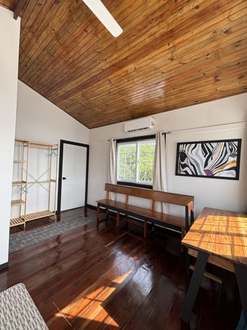 Habitación Premier Queen luminosa en BarrBra BnB en Bocas del Toro con techo de madera, sala de estar y vistas al océano