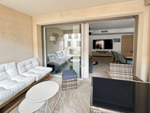 Appartement T4 moderne à Calvi, L'Île-Rousse avec séjour ouvert, canapé blanc, TV écran plat et vue sur balcon