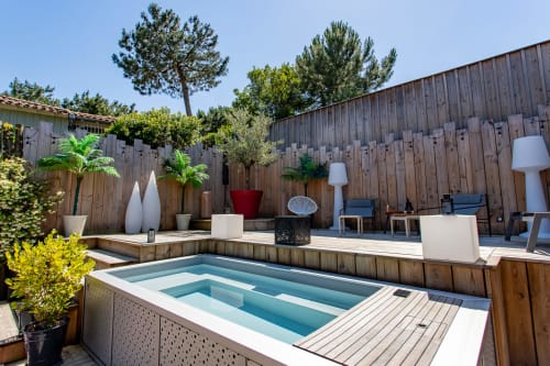 Piscine moderne et terrasse en bois de la villa La Loge Du Bassin à Lège Cap Ferret avec salon de détente et vue sur le jardin