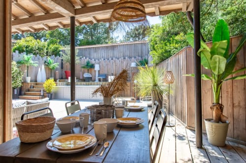 Espace de restauration extérieur à Villa Biscouette, La Loge Du Bassin, Lège Cap Ferret avec accents en rotin et vue sur le jardin