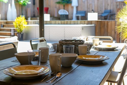 Aménagement de salle à manger en plein air à la Villa Biscouette avec couverts, assiettes jaunes et fleurs jaunes à La Loge Du Bassin, Lège