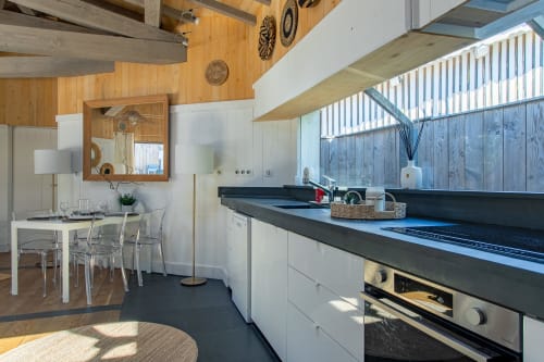 Cuisine moderne aux plans de travail noirs et meubles blancs à la Villa Biscouette, La Loge Du Bassin, Lège Cap Ferret