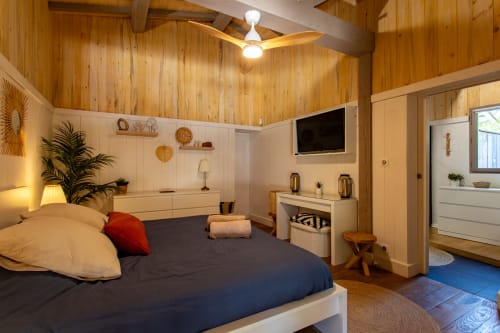 Chambre moderne de la Villa Biscouette à La Loge Du Bassin, Lège-Cap-Ferret, avec plafond en bois, TV et vue sur le jardin