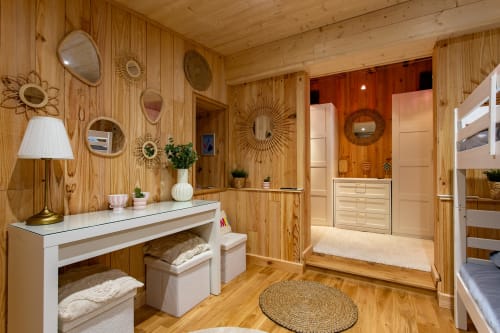 Chambre en bois de la villa La Loge Du Bassin avec coiffeuse, miroirs décoratifs et vue sur le jardin à Lège Cap Ferret