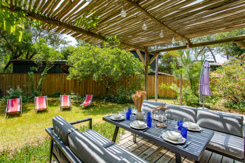 Espace repas extérieur à la villa La Loge Du Bassin avec pergola, transats et tables de jardin à Lège-Cap-Ferret