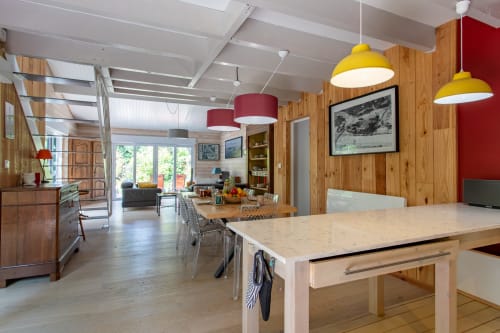 Cuisine et salle à manger contemporaines à La Loge Du Bassin avec murs en bois, suspensions jaunes et vue sur le jardin