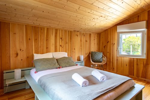 Chambre lumineuse en bois à la Villa Cap à l'Ouest à Lège-Cap-Ferret avec lit queen, serviettes roulées, vue jardin et osier